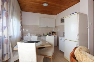 a kitchen with a table and chairs and a refrigerator at Apartments and rooms with parking space Tucepi, Makarska - 5263 in Tučepi