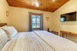 a bedroom with a large bed and a window at *New Owner Special* Cozy Cabin with mountain views in Robbinsville