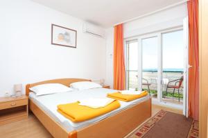 a bedroom with a bed and a large window at Apartments and rooms with parking space Tucepi, Makarska - 5263 in Tučepi