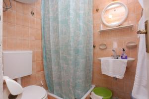 a bathroom with a shower curtain and a toilet at Apartments and rooms with parking space Tucepi, Makarska - 5263 in Tučepi