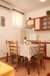 eine Küche mit einem Tisch und Stühlen im Zimmer in der Unterkunft Apartment Kukljica 8237b in Kukljica