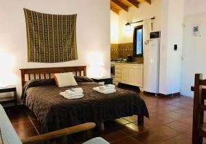 1 dormitorio con 1 cama y cocina con nevera en Cabañas El Francés en Merlo