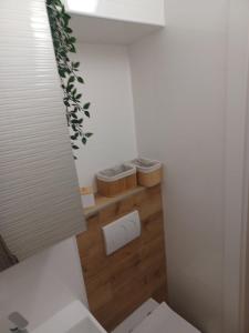 a small bathroom with a toilet and two baskets at Apartment Banjol 4965b in Rab