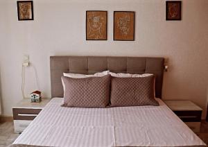 スキアトスタウンにあるFiosal Apartments 1のベッドルーム1室(壁に3枚の写真が飾られたベッド1台付)