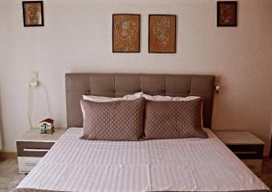 a bedroom with a bed with three pictures on the wall at Fiosal Apartments 1 in Skiathos Town