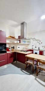 cocina con armarios rojos y mesa de madera en Casa Karmèl en Porto Torres