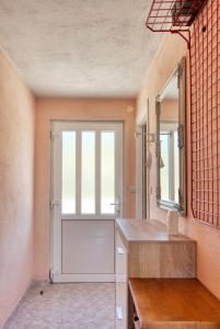 La salle de bains est pourvue d'une porte, d'un lavabo et d'un miroir. dans l'établissement Apartments by the sea Cove Kalebova Luka, Rogoznica - 13804, à Rogoznica