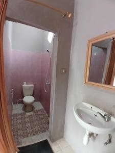 een badkamer met een wastafel en een toilet bij Roby Homestay in Kuta Lombok