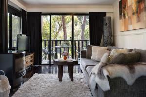 a living room with a couch and a tv at Lardi Lane- romantic getaway in Daylesford