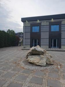 a large rock sitting in front of a building at Pokoje ze wspólną łazienką i kuchnią w centrum Starachowic in Starachowice