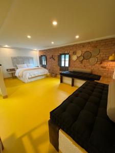 1 dormitorio grande con 1 cama y pared de ladrillo en OPE Suites Usaquen, en Bogotá