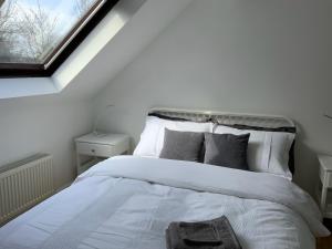 a bedroom with a white bed with a window at Entire house Jersey farm St Albans in Saint Albans