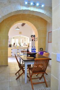 a kitchen and dining room with a table and chairs at Dar Ghax-Xemx Farmhouse in Victoria