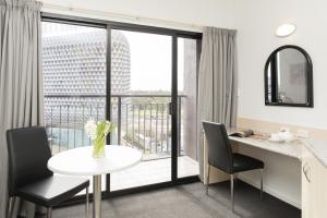 a kitchen with a table and chairs and a balcony at Adelaide Riviera Hotel in Adelaide