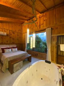 - une chambre avec un lit et une baignoire dans l'établissement Pousada- Cabana Gala Vale das Macieiras Urubici, à Urubici