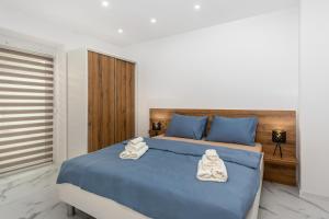 a bedroom with a blue bed with towels on it at Villa Nela Apartments in Crikvenica