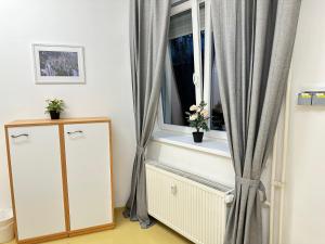 een kamer met een raam met gordijnen en een dressoir bij Railway Ljubljana ROOMS in Ljubljana