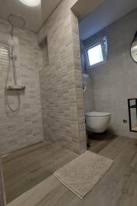 La salle de bains est pourvue d'une douche, de toilettes et d'une fenêtre. dans l'établissement Seaside holiday house Prizba, Korcula - 21583, à Blato