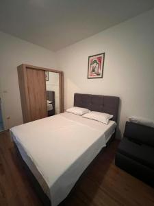 1 dormitorio con 1 cama blanca grande y 1 silla en Apartments with a parking space Kastel Sucurac, Kastela - 21585, en Kaštel Sućurac