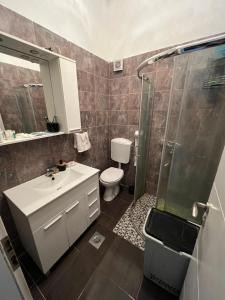 a bathroom with a toilet and a sink and a shower at Apartments with a parking space Kastel Sucurac, Kastela - 21585 in Kastel Sucurac