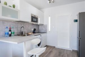 a white kitchen with a sink and a dishwasher at Miramar in Tarajalejo
