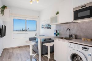 a kitchen with a sink and a washing machine at Miramar in Tarajalejo