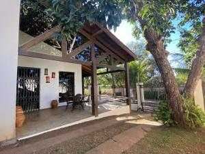 un patio cubierto con una mesa y un árbol en Casa próxima a Praça Central en Chapada dos Guimarães