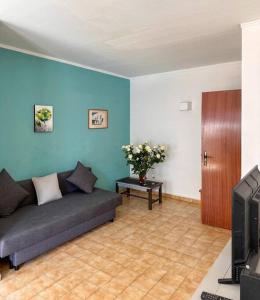een woonkamer met een bank en een tv bij Clube Praia da Rocha II in Portimão