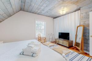 um quarto com uma cama branca e uma televisão em Island Time em Vineyard Haven