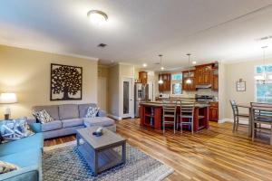 a living room with a blue couch and a kitchen at Gallop Away in Williston