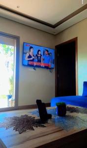 1 dormitorio con 1 cama azul y TV en la pared en Lake House Boulaouane en El Jadida