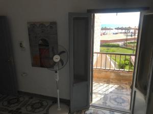 a room with a fan next to a door with a balcony at شالية صف اول على البحر فى قرية الكرمة سيدى عبد الرحمن in El Alamein