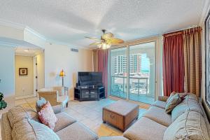 a living room with a couch and a large window at Portofino Island Resort and Spa Tower 1 608 in Pensacola Beach