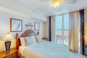 a bedroom with a bed and a large window at Portofino Island Resort and Spa Tower 1 608 in Pensacola Beach
