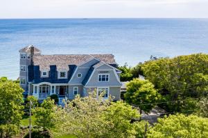 a blue house with the ocean in the background at The Bonnieview in Nameloc Heights