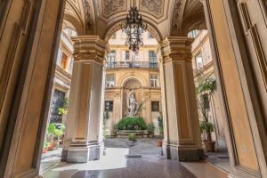 um corredor num edifício com colunas e um lustre em Arenula Suites em Roma