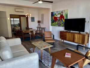 un salon avec un canapé et une télévision à écran plat dans l'établissement Modern city living close to EVERYTHING, à Puerto Vallarta