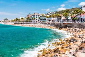 - une plage en face des bâtiments et de l'océan dans l'établissement Modern city living close to EVERYTHING, à Puerto Vallarta