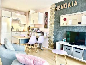 uma sala de estar com um sofá e uma cozinha em CAPORIZON-Santiago-Belle Vue-Parking-T2 plein centre em Hendaye
