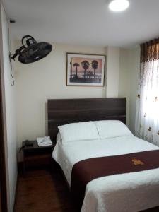 a bedroom with a large bed and a telephone at HOSTAL CORAL in Ilo +8 photos