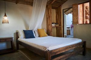 a bedroom with a large bed with blue and yellow pillows at Hostal Juan Palitos in Los Santos