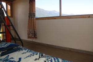 ein Schlafzimmer mit Bett und Fenster mit Aussicht in der Unterkunft Starlight Mountain Lodge SIGCHOS in Sigchos