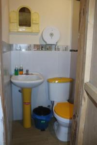 a small bathroom with a toilet and a sink at Starlight Inn in Sigchos