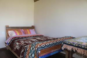 een slaapkamer met een bed en een kussen erop bij Starlight Inn in Sigchos
