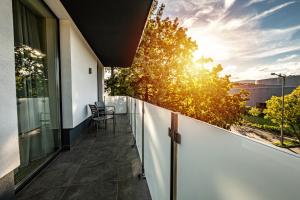 a balcony of a house with a view of the sunset at Lignum Hotel in Miskolctapolca