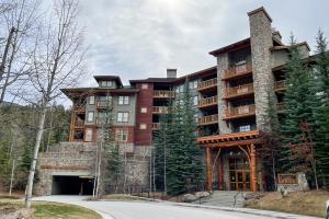 ein großes Apartmenthaus im Wald mit Auffahrt in der Unterkunft Perfect Ski or Bike in-out Hot Tub Pool in Panorama