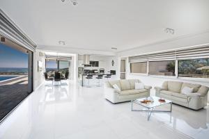 a white living room with two couches and a table at Villa Marilia in Protaras
