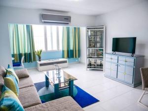 - un salon avec un canapé et une télévision dans l'établissement Hermoso apartamento con acceso al club, à Puerto Palenque
