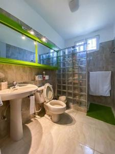 y baño con aseo, lavabo y espejo. en Hermoso apartamento con acceso al club, en Puerto Palenque