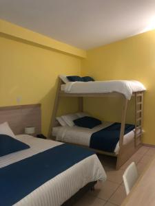 two beds in a room with two bunk beds at Hostel paradise St in Santa Marta